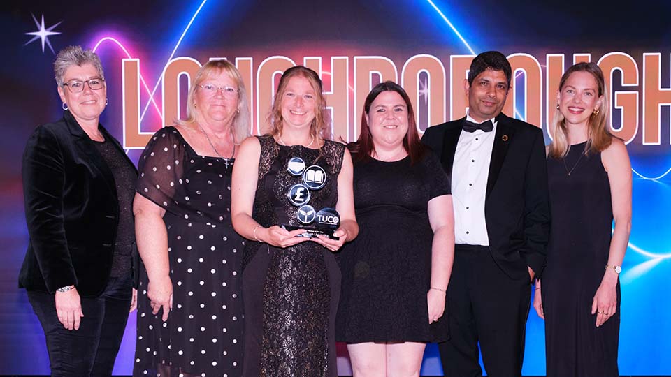 Loughborough colleagues standing together, one of them holding a trophy, at the 2025 TUCO Summer Conference.