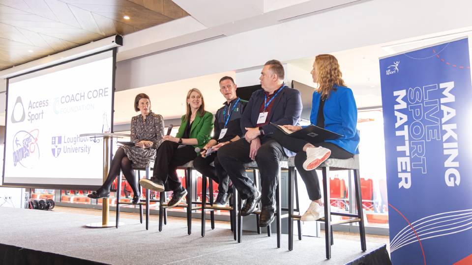 five people sat on stools having a panel discussion