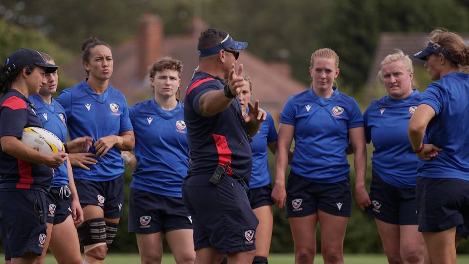 a rugby coach speaks to the players in a semi-circle