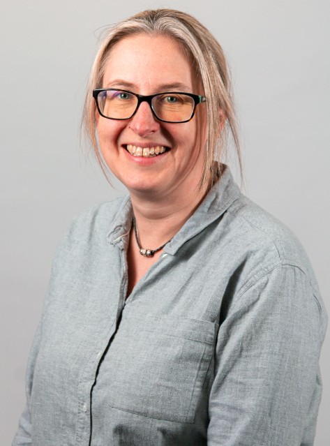 Close-up of Liz Monk in front of a grey background.
