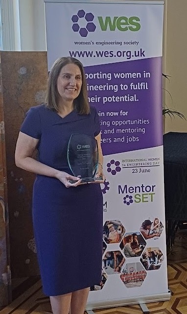 Tanja Radu holding a trophy at the WE50 Awards ceremony.