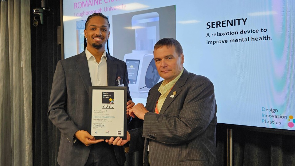 Romaine Crawford holding an award and smiling at the camera.