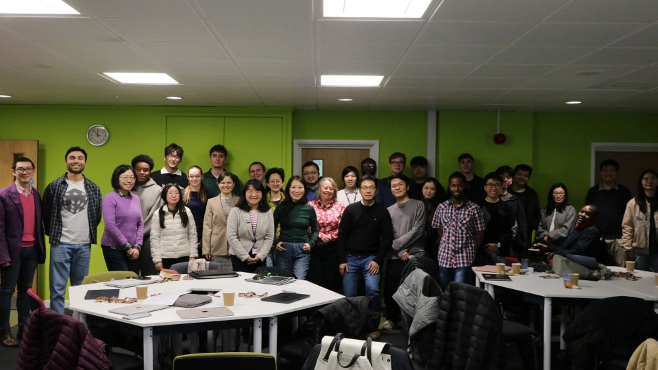 Students and staff stood round tables and smiling at the AI Challenge Camp 2026