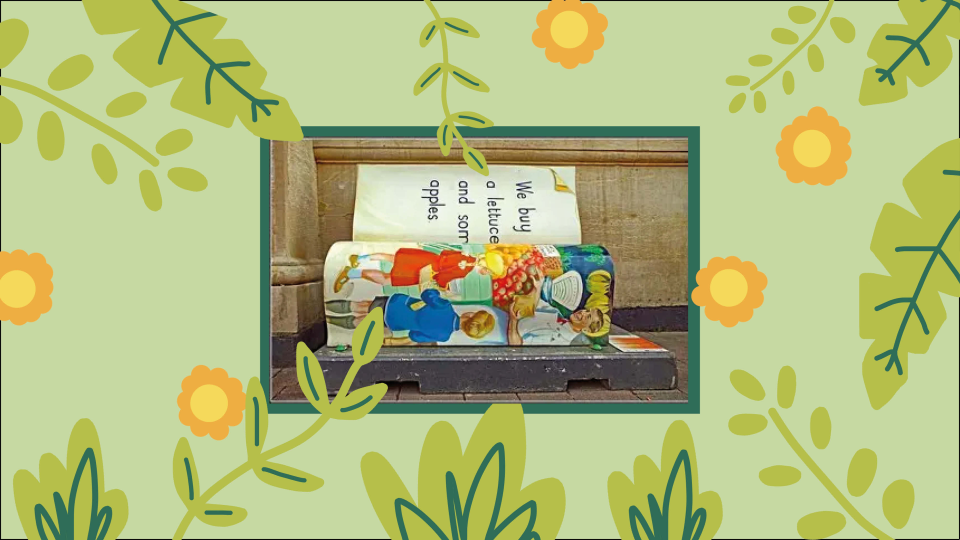 A poster of a light green background, with leaves and yellow flowers. In the center, there is a picture of a book bench with a colourful design.