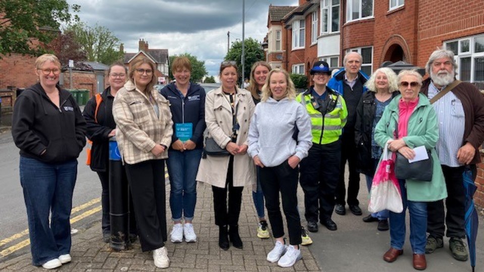 A group of people smiling for a photo on a street.
