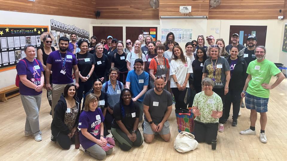 Photo of all of the volunteers from HR sat/stood together in a hall smiling at the camera