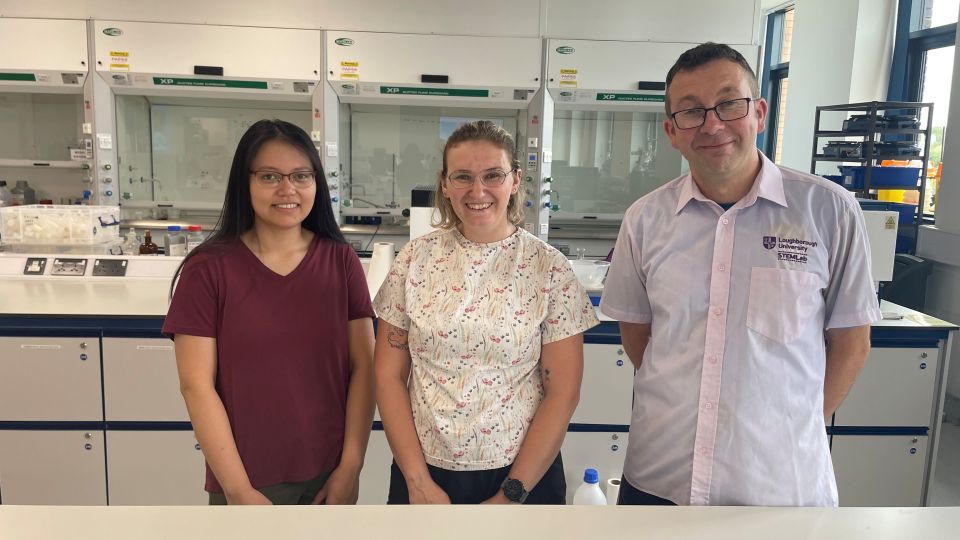 Three Loughborough staff members standing together in a lab.