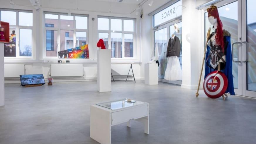 An art exhibition in the Martin Hall Exhibition Space, including clothing and paintings