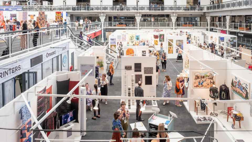 People looking at student work in a large exhibition space.