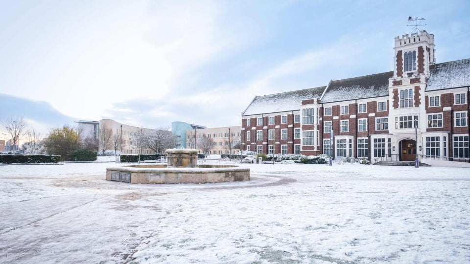 The Hazlerigg building, fountain and the Business School on a bright snowy winter's day