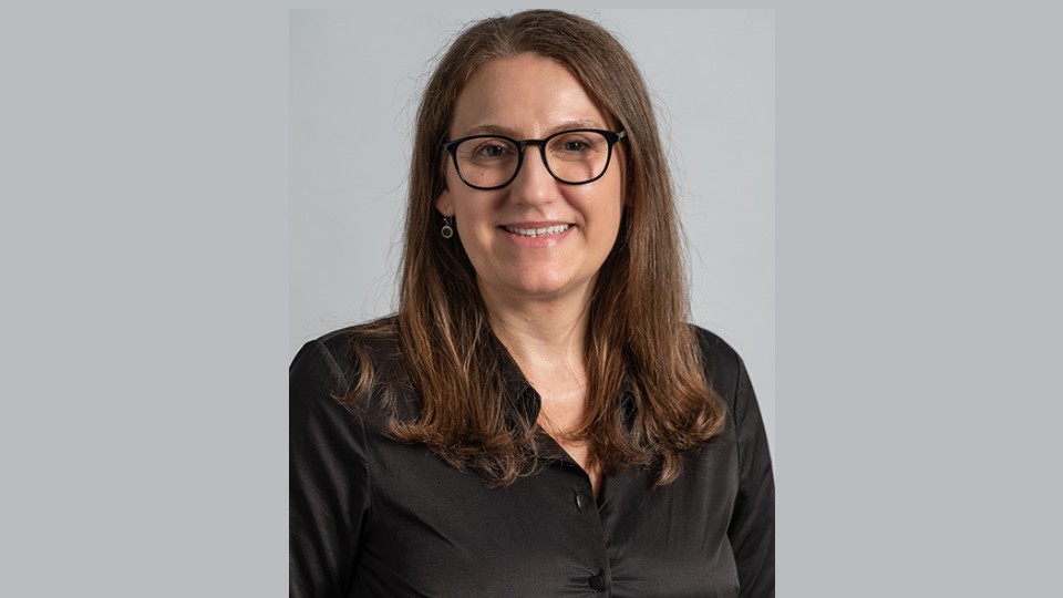 Close-up of Tanja Radu in front of a grey background.